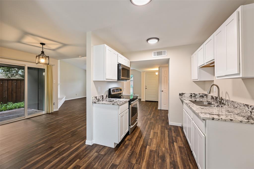 7318 Emory Oak Lane Dallas, TX 75249 - Photo 7 of 28 Kitchen featuring white cabinetry, stone countertops, stainless steel appliances, and wood-finish flooring