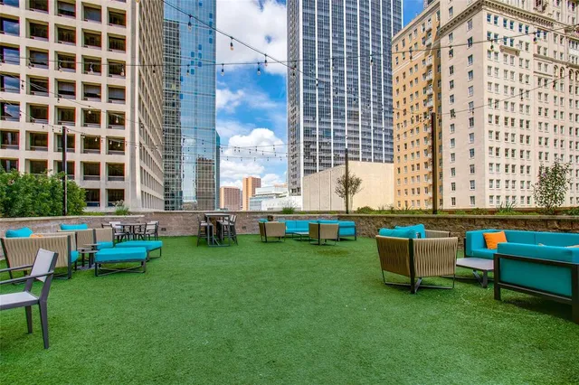 a backyard of a building with lawn chairs and couches