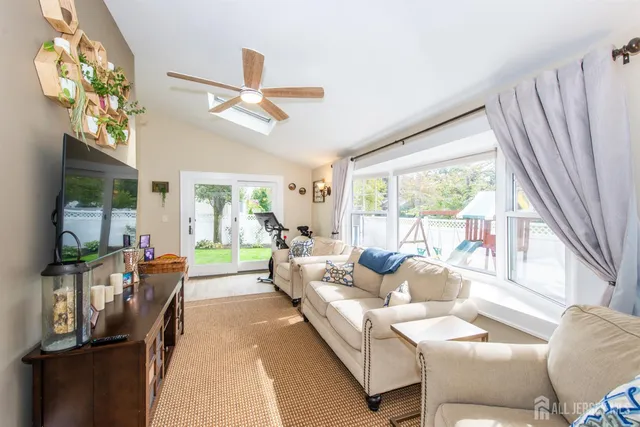 a living room with furniture a flat screen tv and a large window