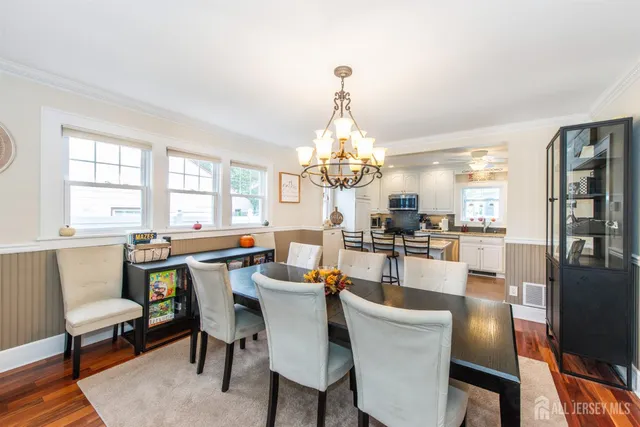 a view of a dining room with furniture a chandelier and wooden floor