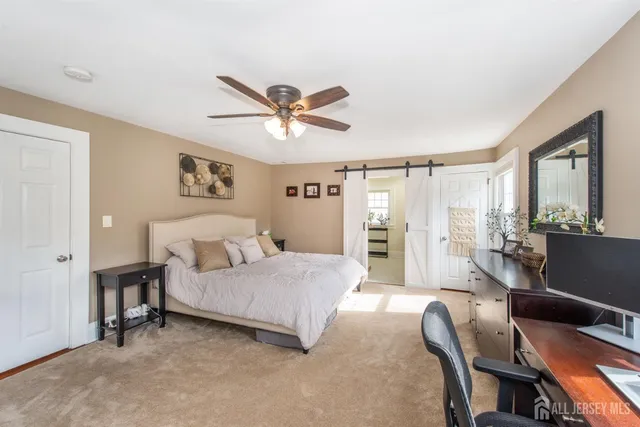 a bedroom with a bed a couch and a large window
