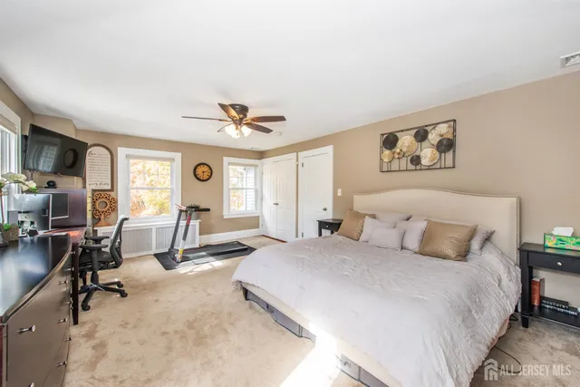 a bedroom with a bed a desk and chair with the wooden floor