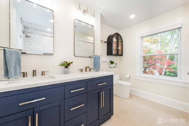 a bathroom with a granite countertop sink mirror and toilet