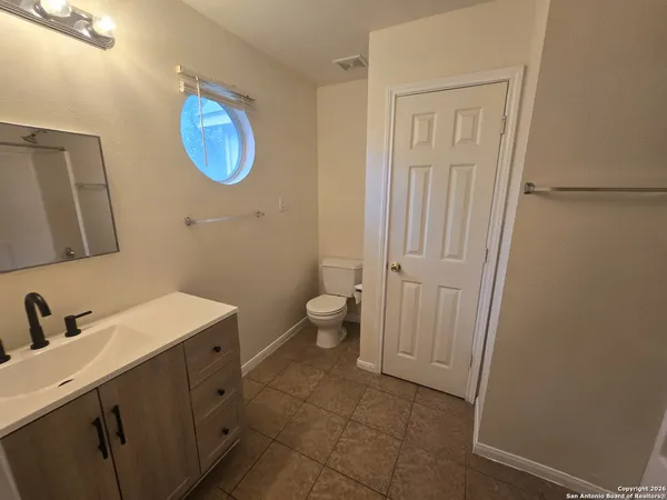 a bathroom with a sink a toilet and mirror