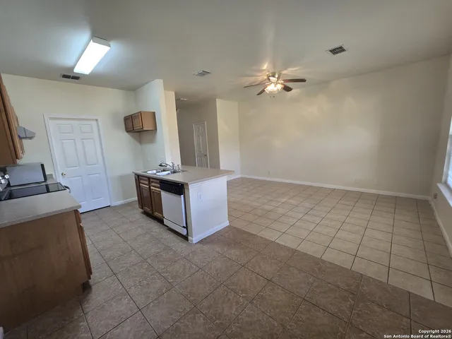 a kitchen with granite countertop a stove a sink and a refrigerator