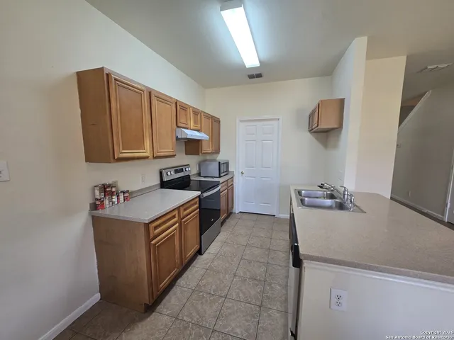a kitchen with a sink and a stove top oven