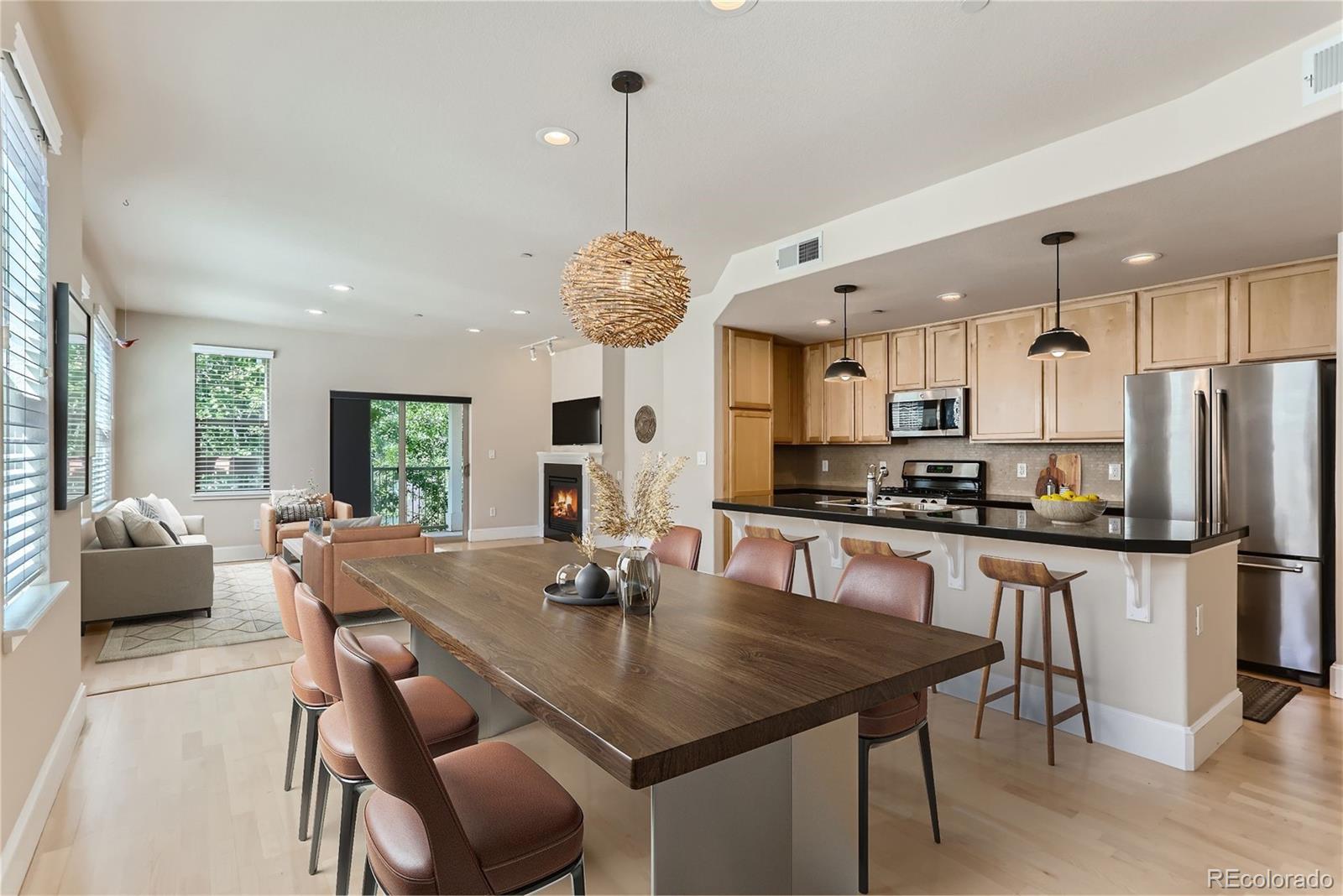 a kitchen with stainless steel appliances granite countertop a kitchen island a table and chairs in it