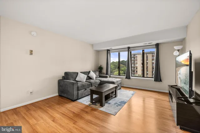 a living room with furniture large window and flat screen tv