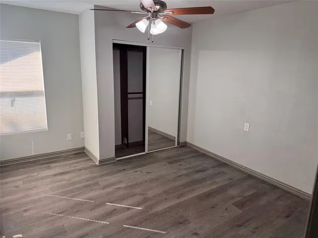 an empty room with fan and windows