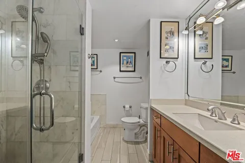 a bathroom with a granite countertop sink toilet and shower