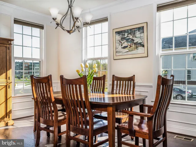 a kitchen with stainless steel appliances granite countertop a stove a sink a refrigerator a center island a table and chairs