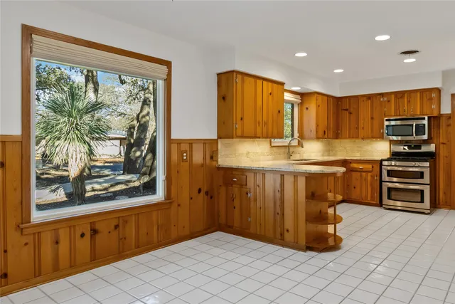a kitchen with stainless steel appliances granite countertop a sink and cabinets