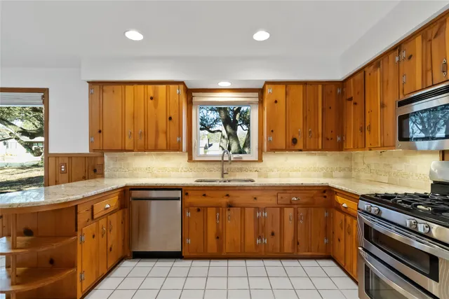 a kitchen with stainless steel appliances granite countertop a sink and cabinets