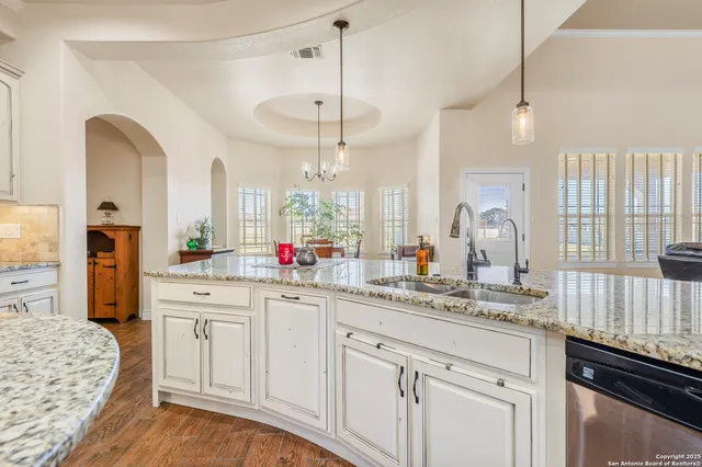 a kitchen with white cabinets and sink