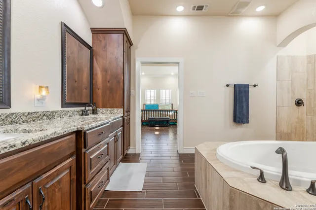 a bathroom with a tub sink and mirror