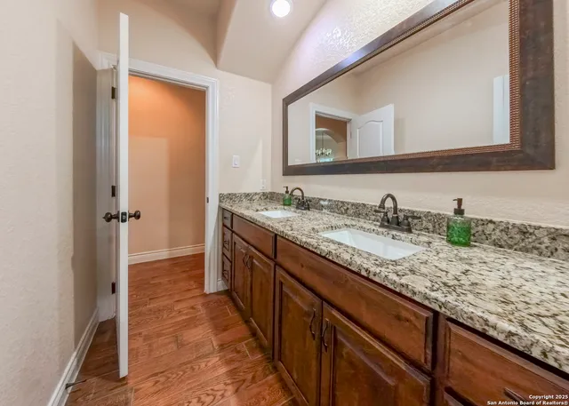 a bathroom with a granite countertop sink and a mirror