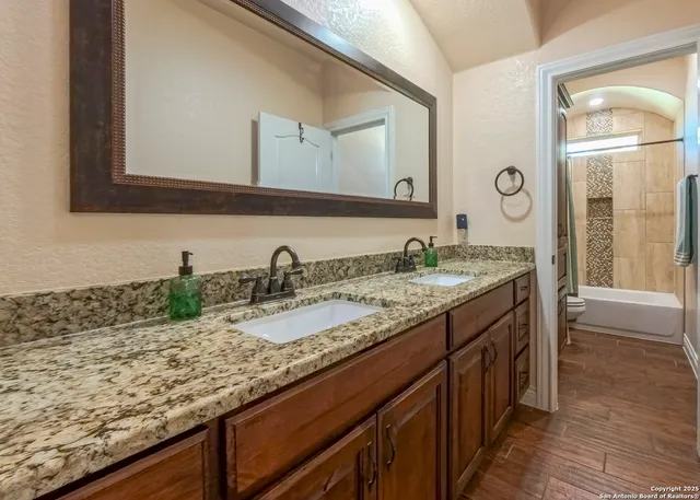 a bathroom with a granite countertop sink and a mirror