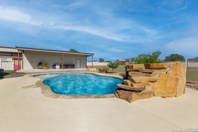 front view of a house with swimming pool and sitting area