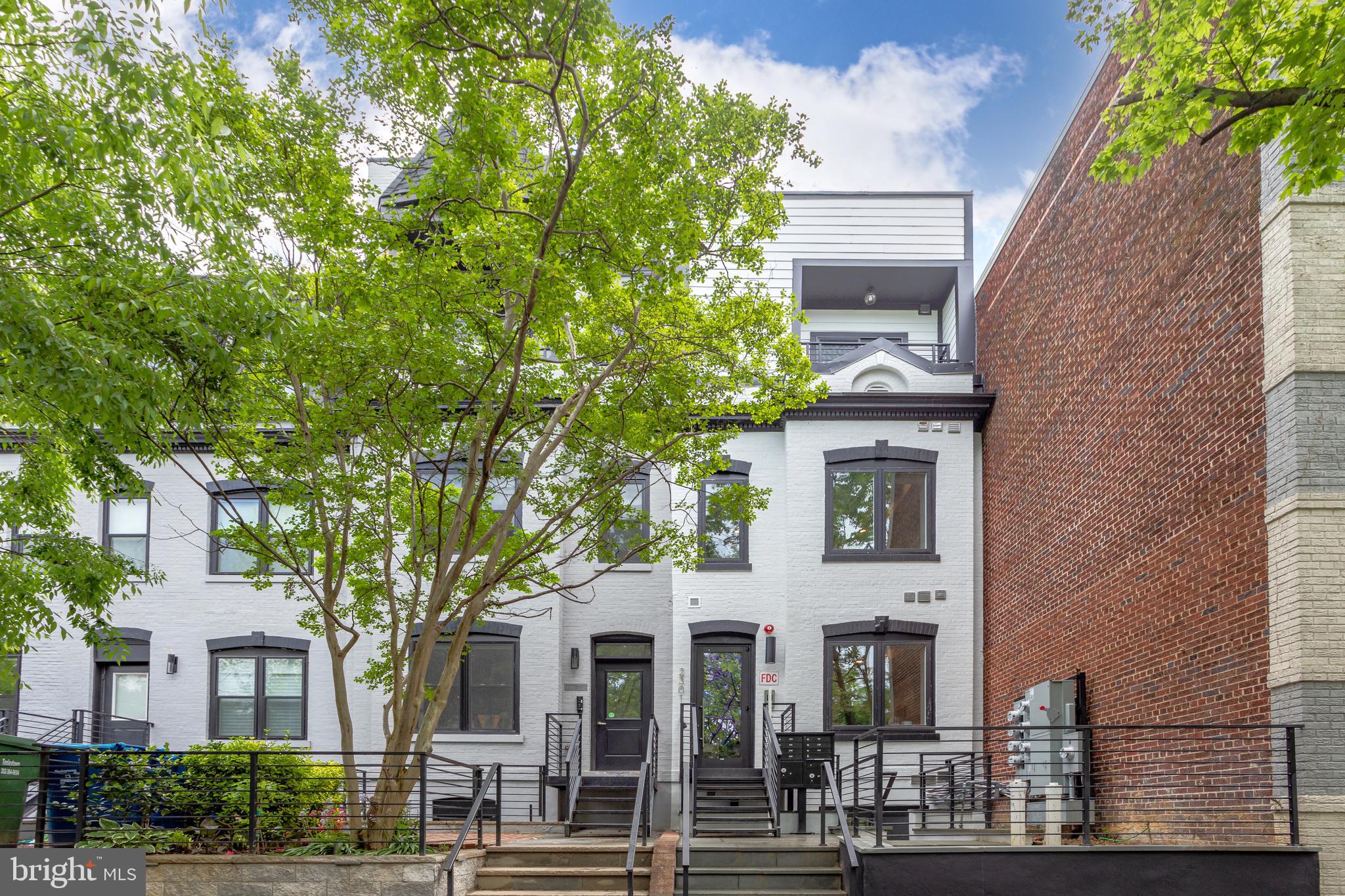 2301 Ontario Road Northwest, Unit 101 Washington, DC 20009 - Photo 1 of 24 a view of a white house with a tree front of it