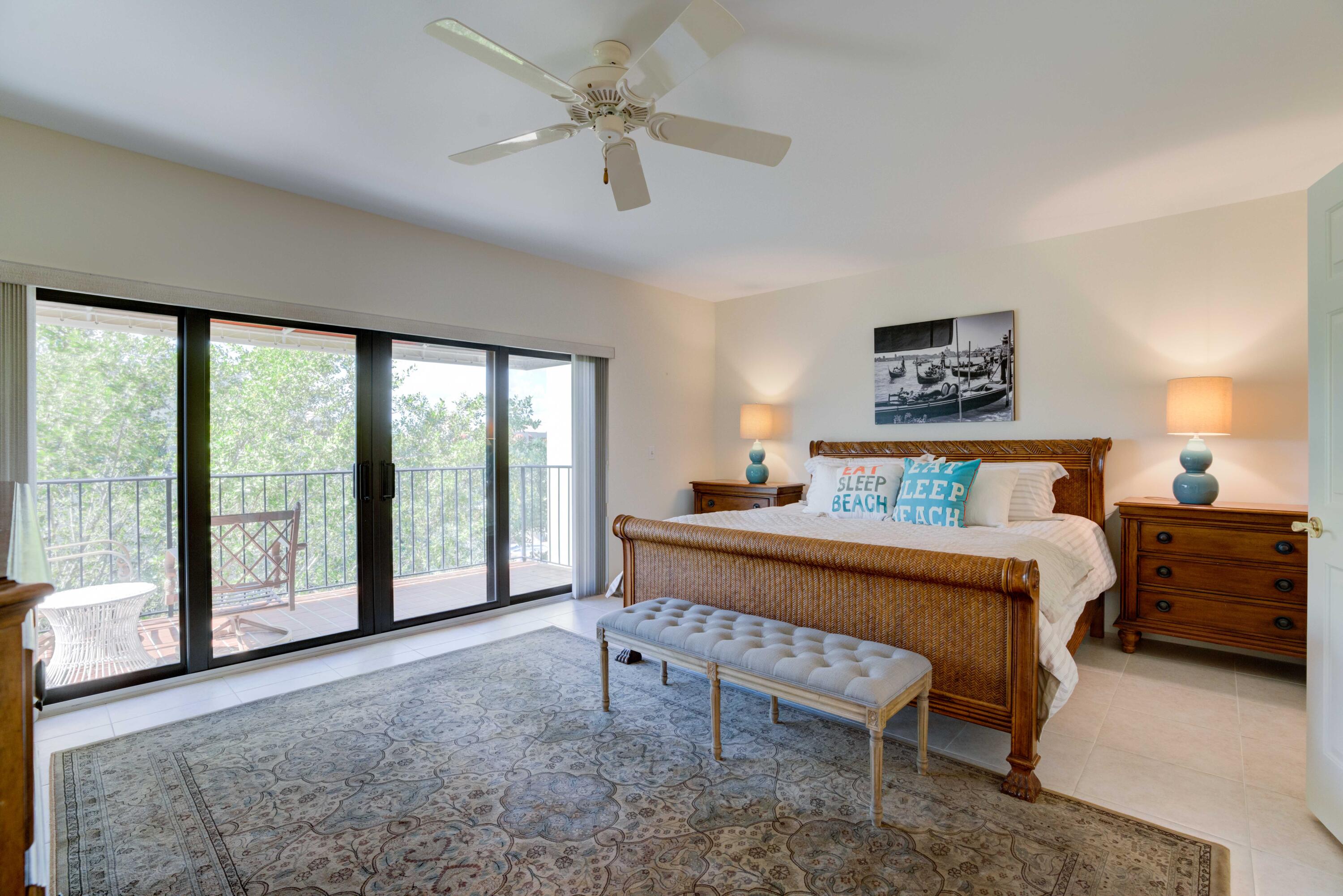 170 Celestial Way, Unit 32 Juno Beach, FL 33408 - Photo 23 of 30 a bedroom with a balcony a bed and a chandelier