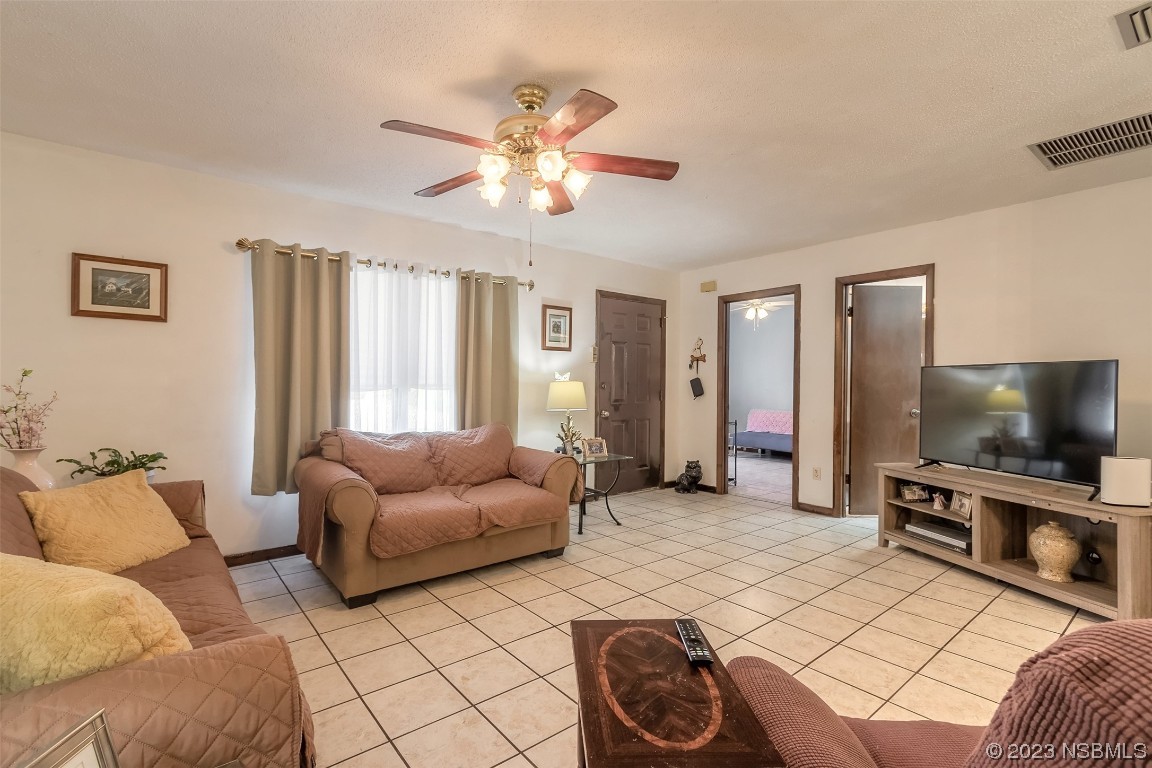 2908 Orange Tree Drive Edgewater, FL 32141 - Photo 11 of 30 a living room with furniture and a flat screen tv
