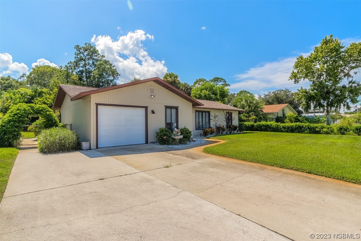2908 Orange Tree Drive Edgewater, FL 32141 - Photo 2 of 30 a front view of a house with a yard and garage
