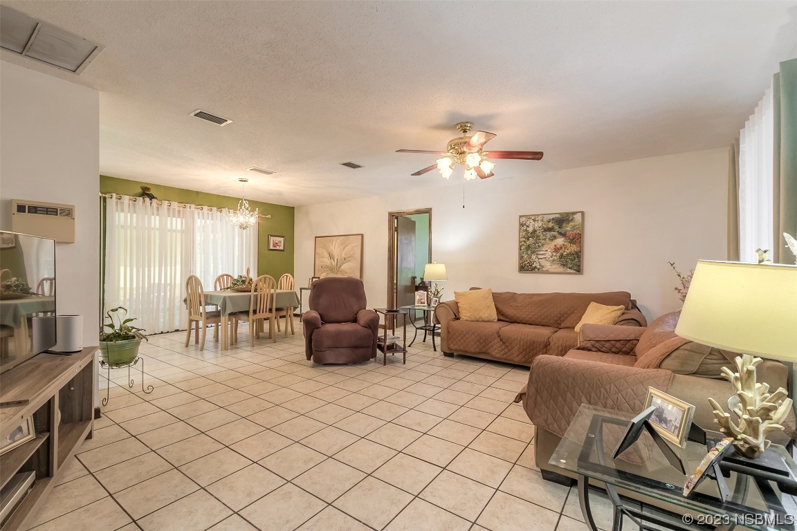 2908 Orange Tree Drive Edgewater, FL 32141 - Photo 9 of 30 a living room with furniture and a chandelier