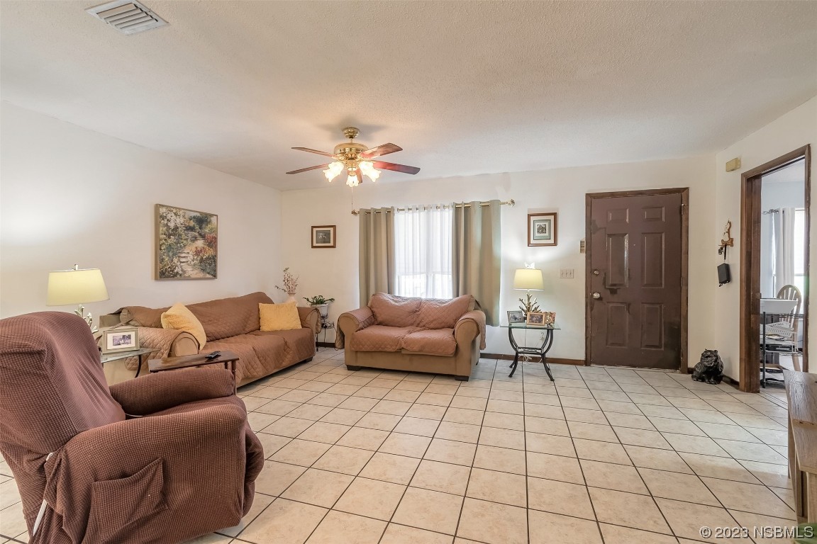 2908 Orange Tree Drive Edgewater, FL 32141 - Photo 10 of 30 a living room with furniture and a chandelier