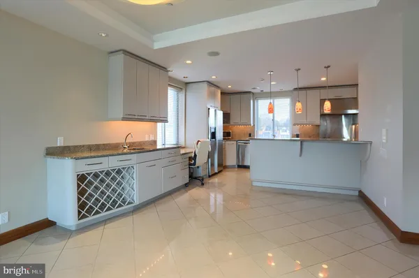a large kitchen with a large counter top stainless steel appliances and cabinets