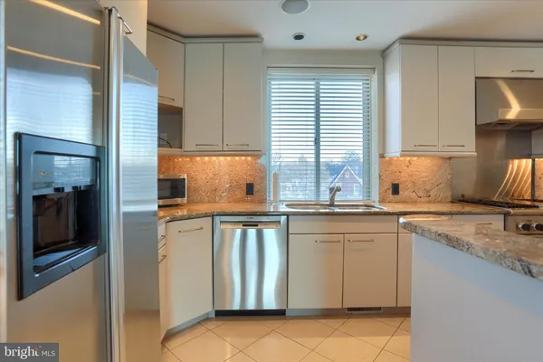 a kitchen with stainless steel appliances granite countertop a sink and cabinets