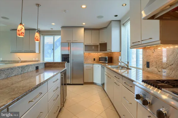 a kitchen with granite countertop a sink stainless steel appliances and cabinets