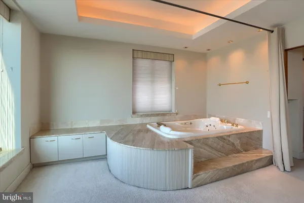 a bathroom with a tub sink and mirror
