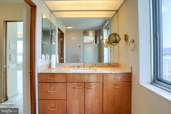 a bathroom with a granite countertop sink and a mirror