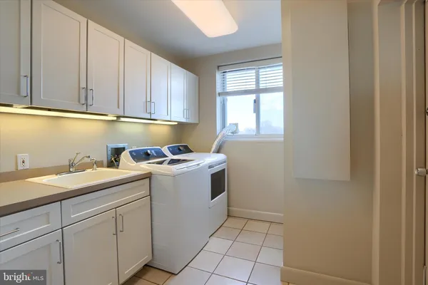 a utility room with sink dryer and washer
