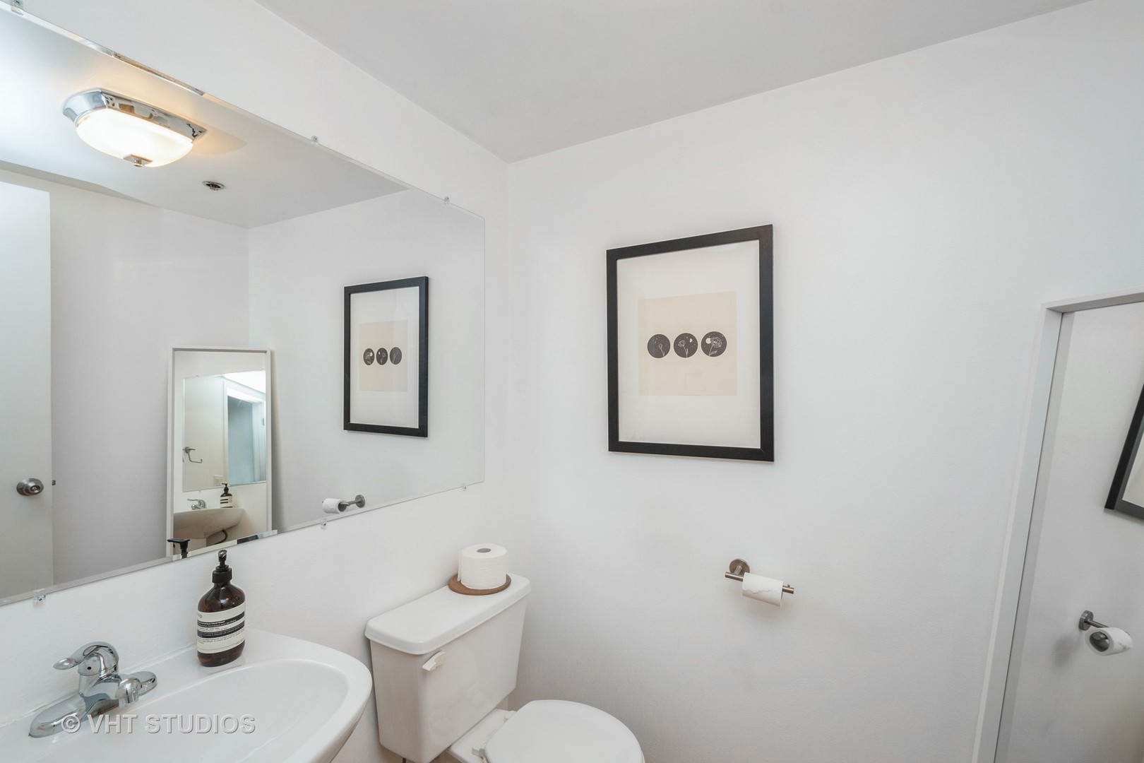 1601 South Indiana Avenue, Unit 407 Chicago, IL 60616 - Photo 12 of 16 a bathroom with a toilet a sink and mirror