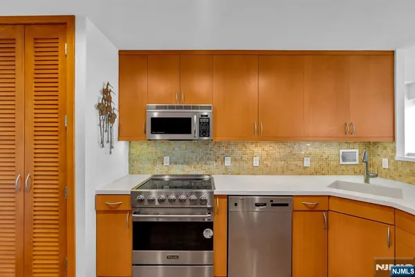 a large kitchen with a wooden floor and stainless steel appliances