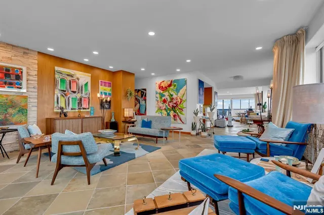 a living room with furniture kitchen view and a large window