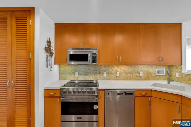 a kitchen with stainless steel appliances a stove a sink and a microwave