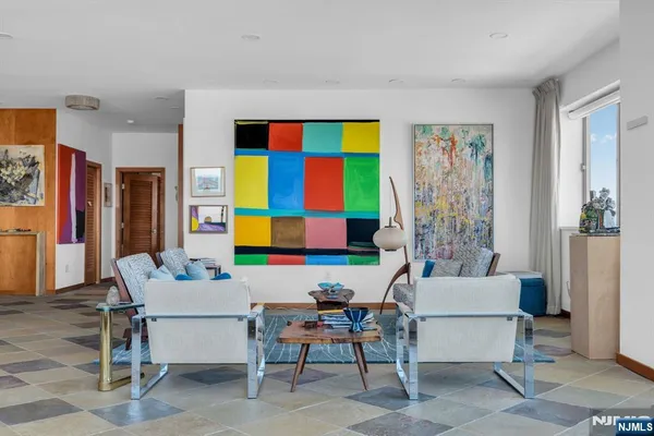 a living room with furniture a rug and a painting