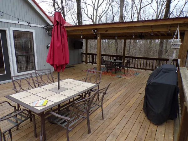 a view of a patio with table and chairs with wooden floor and fence