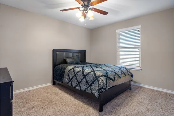 a bed sitting in a bedroom next to a window