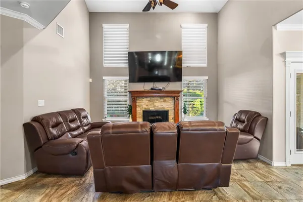 a living room with furniture a flat screen tv and a fireplace
