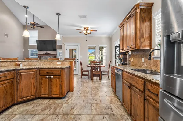 a kitchen with stainless steel appliances granite countertop a sink counter space cabinets and a stove