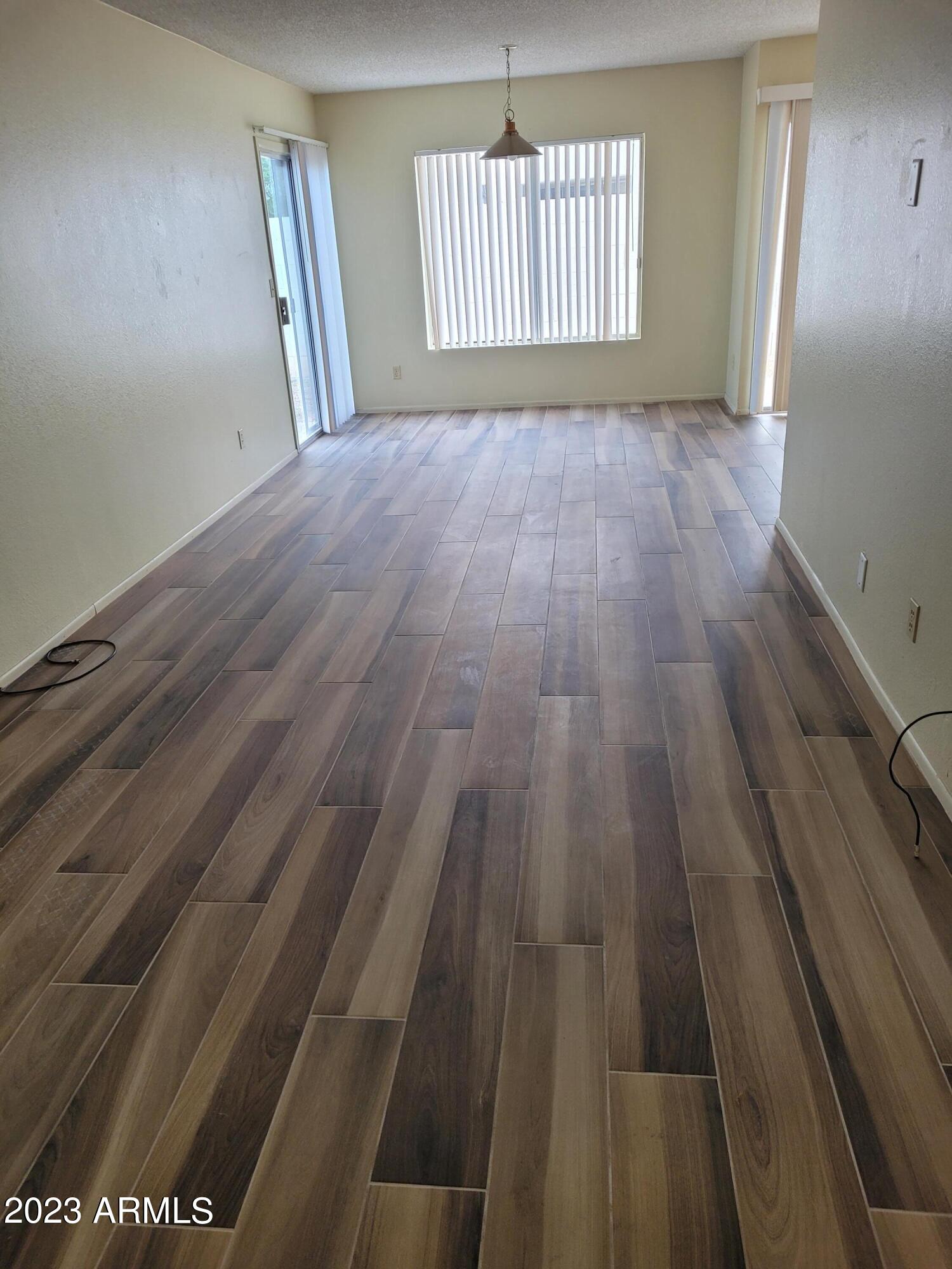 750 East Michelle Drive Phoenix, AZ 85022 - Photo 2 of 7 an empty room with wooden floor and windows