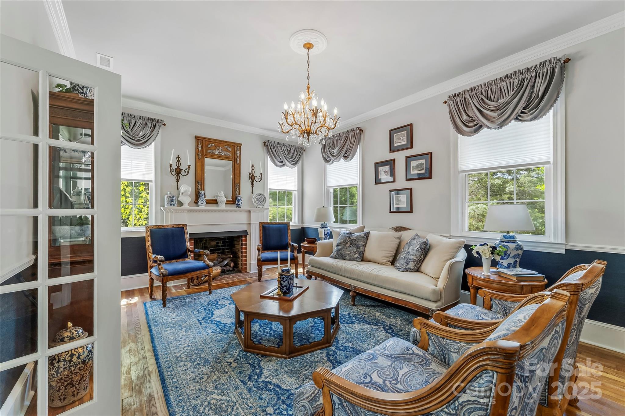 a living room with furniture a fireplace and a chandelier
