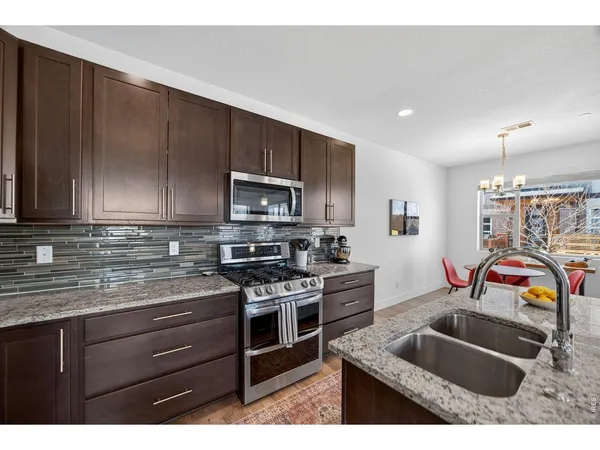 a kitchen with stainless steel appliances kitchen island granite countertop a sink stove and cabinets