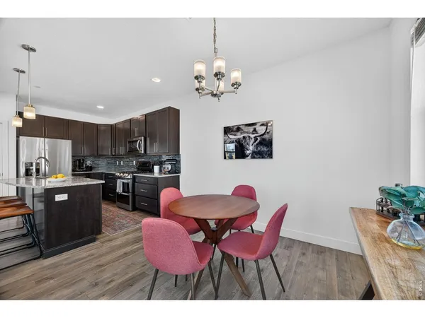 a view of kitchen with dining area a refrigerator a dining table and chairs