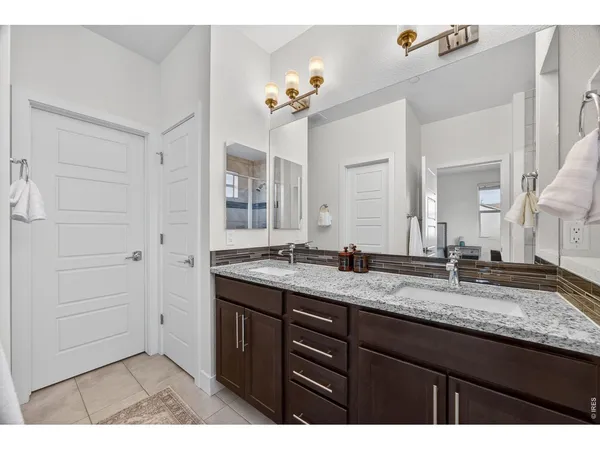 a bathroom with a granite countertop sink a large mirror and a shower