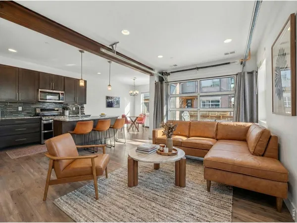 a living room with furniture and a view of kitchen