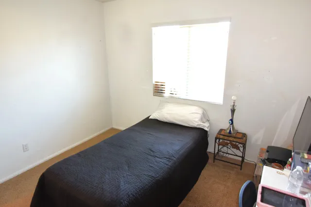 a bedroom with a bed and a dresser in it